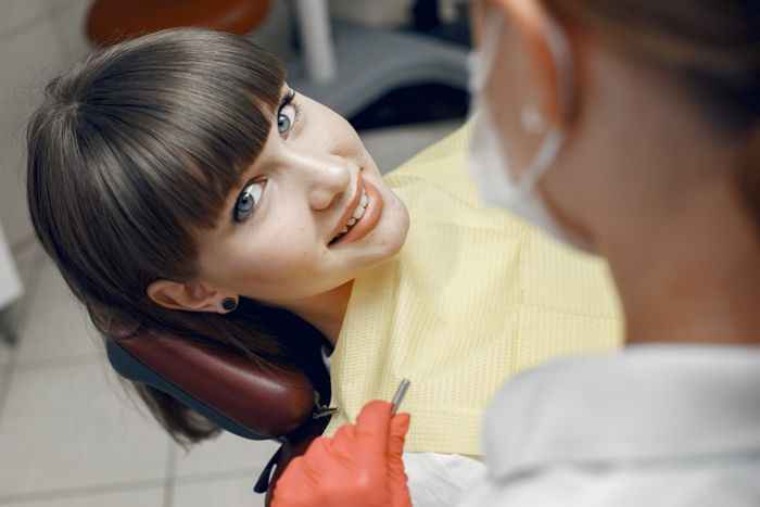 Paciente sorrindo em consultório odontológico